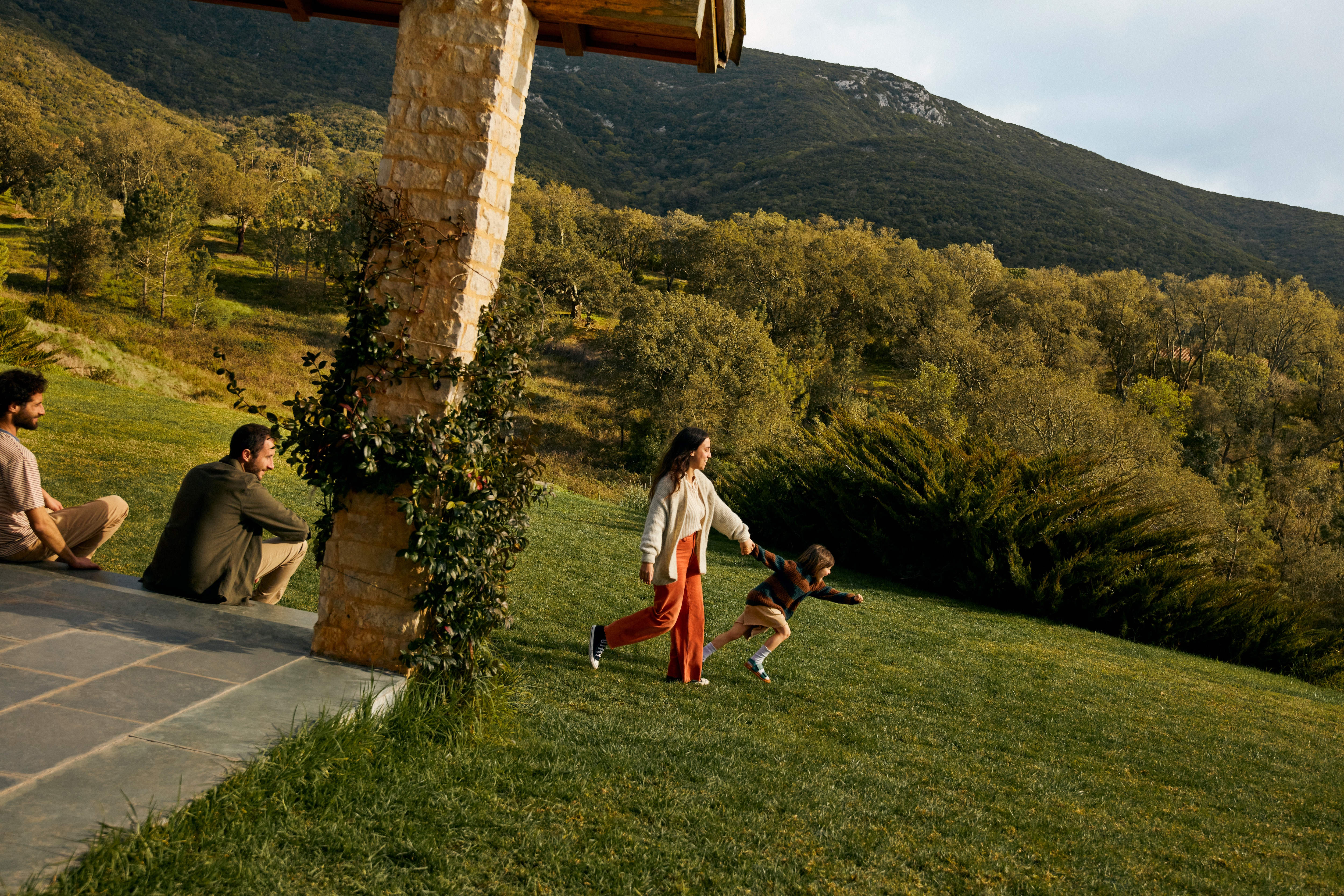 A child excitedly guides an adult across a field.